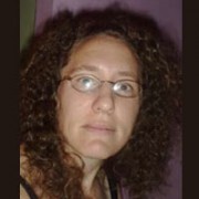 Bernice Darling Woman with long dark curly hair and glasses
